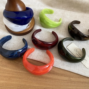 Detailed collection of colorful chunky acrylic C-shaped bangles in various marbled finishes