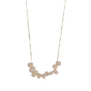 Minimalist gold necklace with nine white freshwater pearls on a smile pendant design