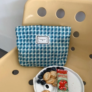 Détail de la trousse tissée à carreaux bleu et blanc avec étiquette en tissu blanc