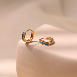 Detail view of 18K gold plated hoop earrings with inlaid rectangular turquoise stones