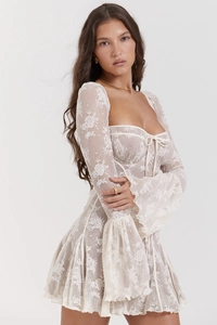 Dettaglio dell'abito in pizzo bianco con eleganti maniche a campana e vita a corsetto