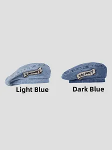 Detail view of denim beret hats in light and dark blue with DG FAMILY embroidery
