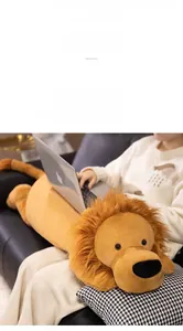 Close-up of soft plush lion doll used as a laptop cushion on a person's lap