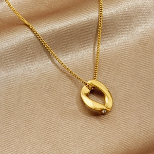 Gold stainless steel necklace with twisted oval mobius pendant and sparkling crystal