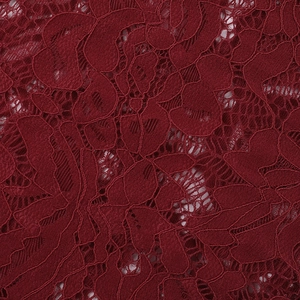 Macro shot of high-density floral lace fabric in deep burgundy for long sleeve bodysuit