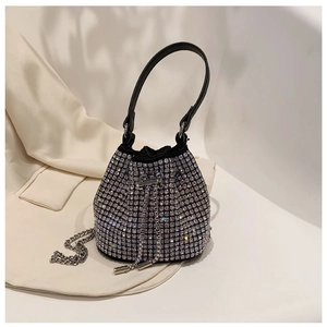 Macro shot of silver rhinestone bucket bag with black leather handle and drawstring closure