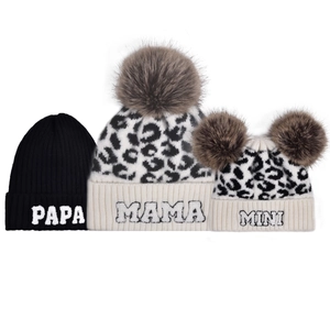 Detail of leopard print and black knit beanies with Papa Mama Mini embroidery and fur pompom