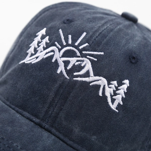 Macro shot of mountain forest embroidery on dark blue washed cotton baseball cap