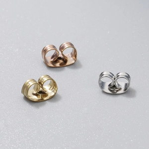 Détail de trois fermoirs papillon en acier inoxydable plaqué or 18 carats de diverses couleurs