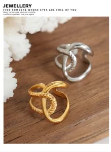 Detail showing intertwined gold and silver rings with textured rope and smooth finishes