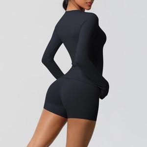 Detail view showing black long sleeve yoga top and high waist shorts on a model