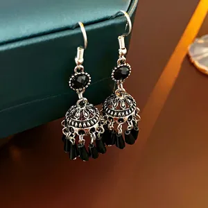 Detail of vintage silver jhumka earrings with black beads on a luxury display