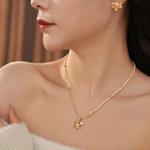 Elegant gold butterfly jewelry set featuring a pearl necklace and matching stud earrings