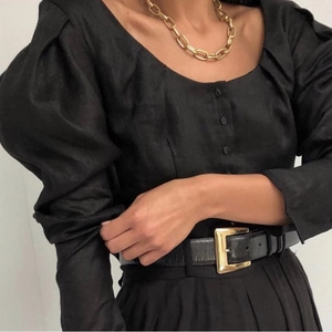 Detail of 18k gold vacuum plated chunky cuban link chain worn with black retro puff sleeves