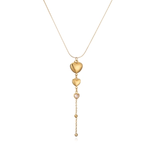 Detailed view of gold heart pendant necklace with shimmering clear gemstone on white background