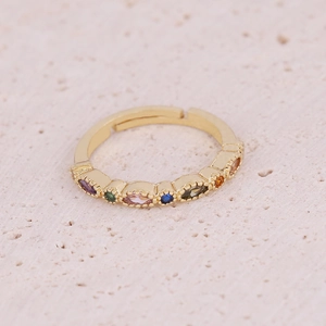 Detail of gold-plated eye ring with marquise-cut colored zircons on stone background