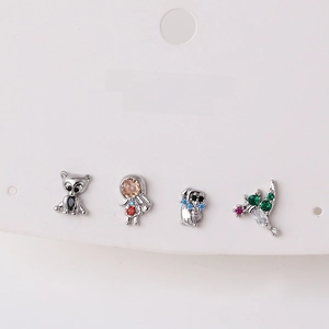 Detailed macro view of four small animal stud earrings with micro-set zircon stones