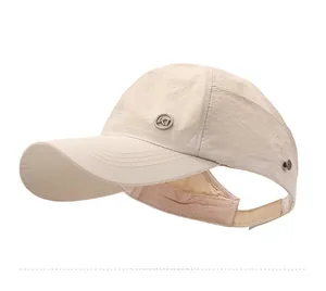 Detail view of beige quick-dry sun visor hat with metal logo and adjustable ponytail opening