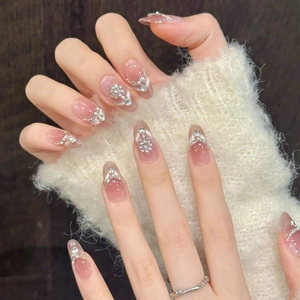 Long almond press-on nails with peach blush cat-eye gradient, silver rhinestones, and pearls