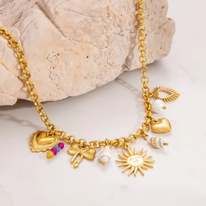 Detailed shot of 18k gold sun shell pendant necklace with charms and pearls on marble