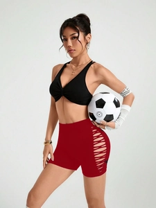 Détail du short de fitness taille haute avec découpes latérales et tissu rouge technique