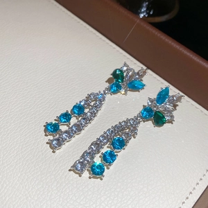 Detail of silver floral drop earrings with blue and green crystals in a luxury jewelry box