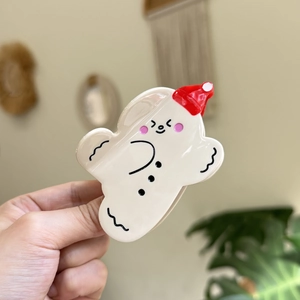 Gros plan d'une jolie pince à cheveux bonhomme de neige nuage blanc avec bonnet de Noël