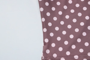 Détail du tissu marron à pois roses avec des coutures doubles de haute qualité