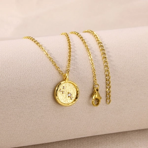Macro shot of gold-plated circular zodiac pendant with inlaid sparkling zircon stones