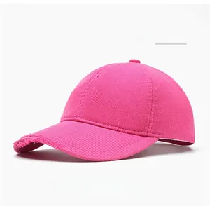 Detail of rose red cotton baseball cap featuring trendy frayed edges and vintage distressed brim