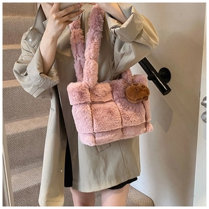 Pink plush woven shoulder bag with cute brown bear charm detail shown on model