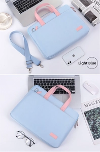Light blue laptop bag with pink handles and shoulder strap shown in a workspace setup