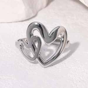 Close-up of overlapping heart-shaped hollow ring with shiny metallic silver finish