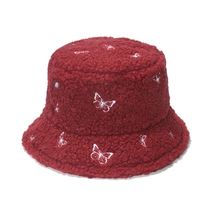 Detail of dark red faux shearling bucket hat featuring white butterfly embroidery