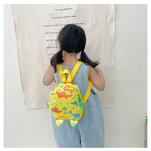 Toddler yellow backpack with colorful cartoon dinosaur prints worn by a child