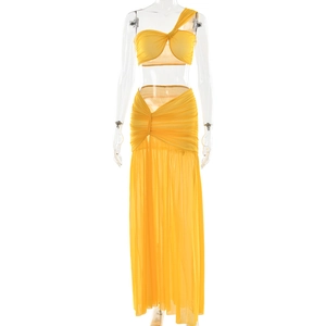 Detail of yellow one-shoulder top and high-waisted mesh maxi skirt with side slit detail