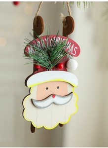 Macro view of wooden Santa ornament with pine needles and Merry Christmas text