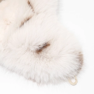 Detailed close-up of thick faux fur lining and beige woven loop on white trapper hat