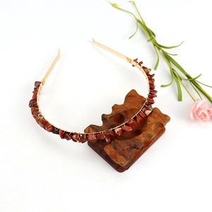 Handmade gold headband with double-row reddish-brown natural crystal stones on wood