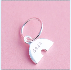 Macro shot of S925 sterling silver rainbow charm showing fine texture and authentic hallmark