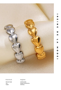 Close-up of gold and silver heart-shaped stacking rings on champagne silk fabric