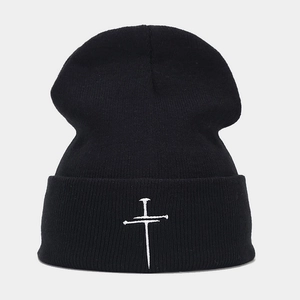 Close-up of white cross embroidery on black ribbed knit beanie with gothic style