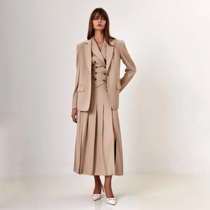 Détail d'un élégant costume beige trois pièces avec gilet croisé et jupe plissée chic