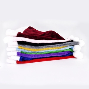 Colorful stack of premium plush Christmas hats in red, pink, and assorted soft colors