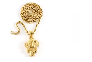 Macro detail of gold-plated Desert Eagle hip-hop pendant with box chain on white background
