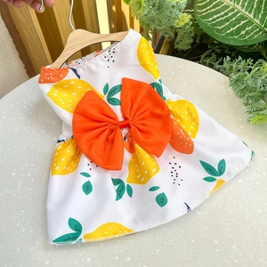 Detailed view of a pet dress featuring yellow lemon prints and an orange decorative bow