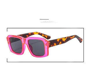 Detail close-up of retro square sunglasses with pink frames and leopard print temples