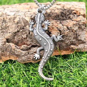 Pendentif gecko gothique en acier inoxydable argenté rétro posé sur du bois rustique