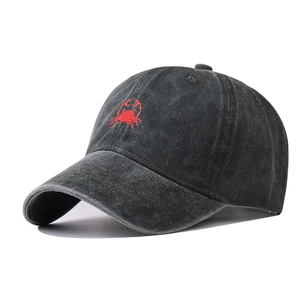 Detail of dark grey washed cotton baseball cap featuring red crab embroidery texture