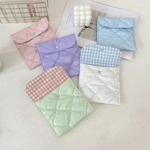 Close-up of colorful quilted satin organizer pouches with cute heart buttons for cosmetics